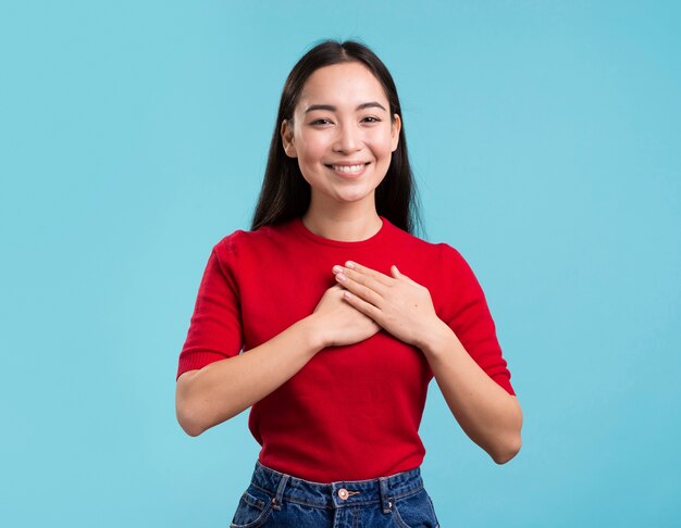 Mujer sonriente con las manos en el corazón