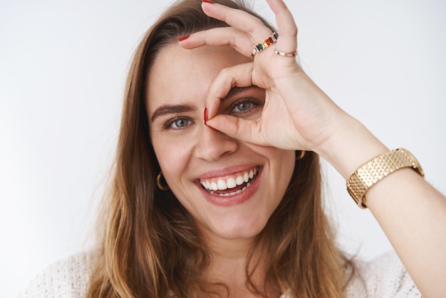 Mujer sonriente manteniendo una actitud positiva mostrando bien ok gesto mirando sonriendo felizmente divirtiéndose disfrutando de los rayos del sol de primavera