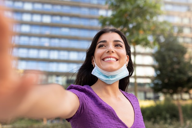 Foto gratuita mujer sonriente con mascarilla de tiro medio