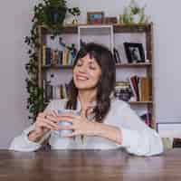 Foto gratuita mujer sonriente en mesa con café