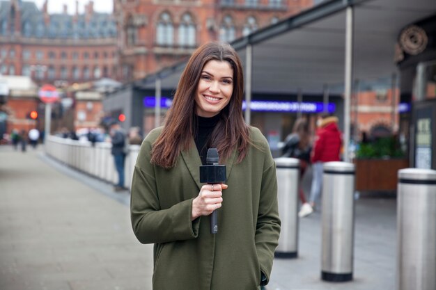 Mujer sonriente con micrófono de tiro medio