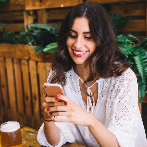 Mujer sonriente mirando a smartphone