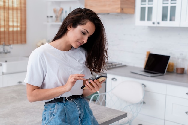 Foto gratuita mujer sonriente mirando su teléfono