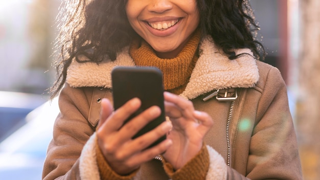 Mujer sonriente mirando su teléfono