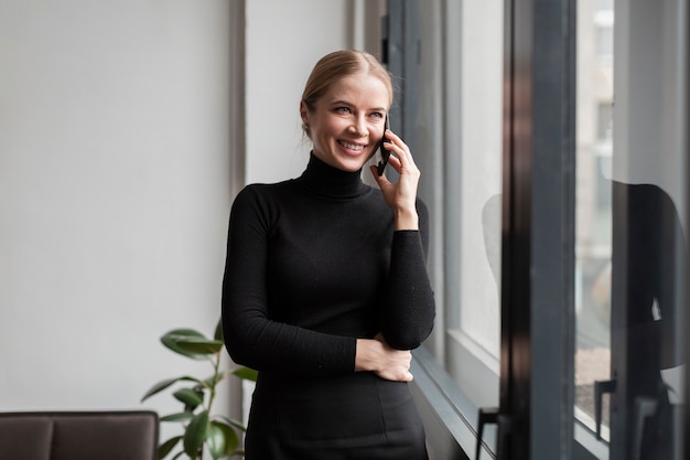 Mujer sonriente moderna hablando por teléfono