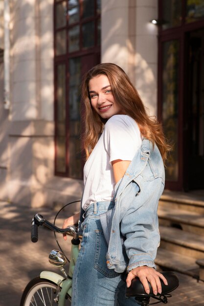 Mujer sonriente montando su bicicleta en la ciudad