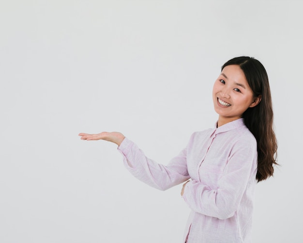 Mujer sonriente mostrando espacio en blanco