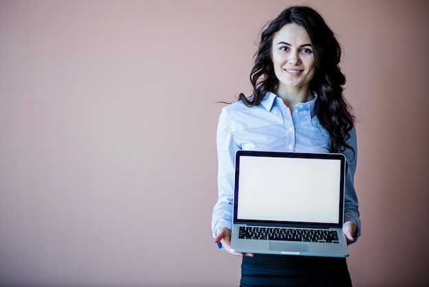 Mujer sonriente mostrando portátil