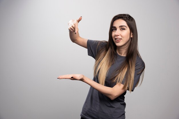 Mujer sonriente mostrando su mano y posando