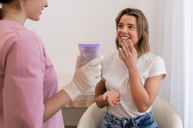 Mujer sonriente obteniendo relleno de labios de cerca