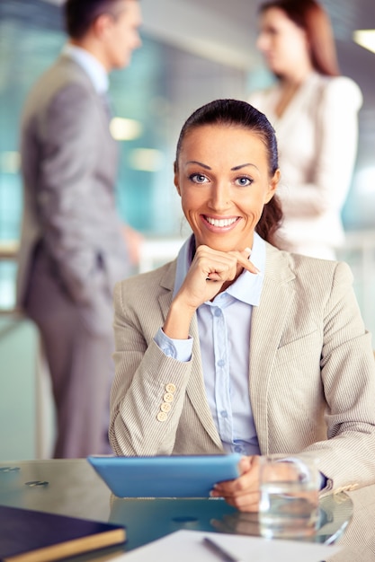 Foto gratuita mujer sonriente en la oficina con la tableta