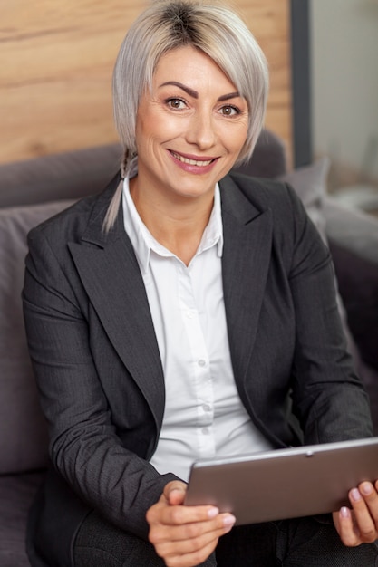 Foto gratuita mujer sonriente en la oficina con tableta