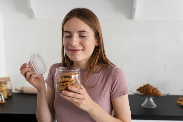 Foto gratuita mujer sonriente oliendo unas deliciosas galletas