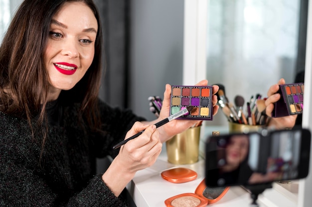 Mujer sonriente con paleta de maquillaje