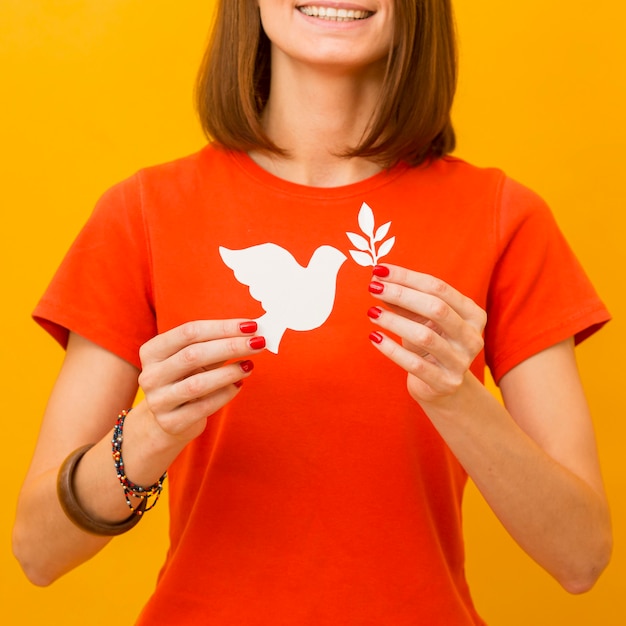 Mujer sonriente con paloma de papel