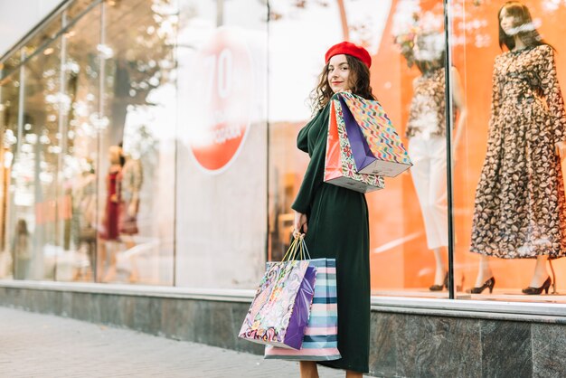 Mujer sonriente con paquetes de colores en el caso