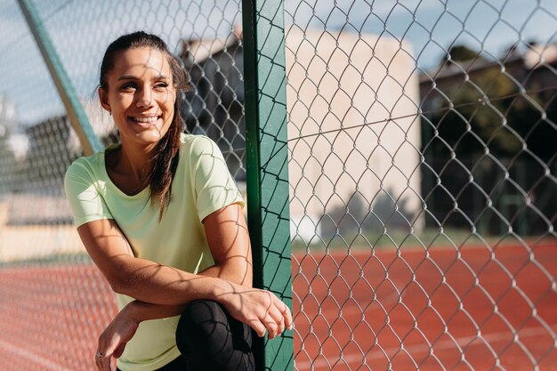 Mujer sonriente pasando tiempo libre para entrenar en aire fresco