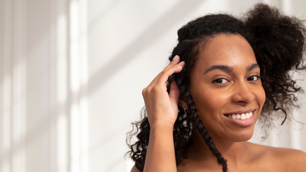 Mujer sonriente peinar el cabello de cerca