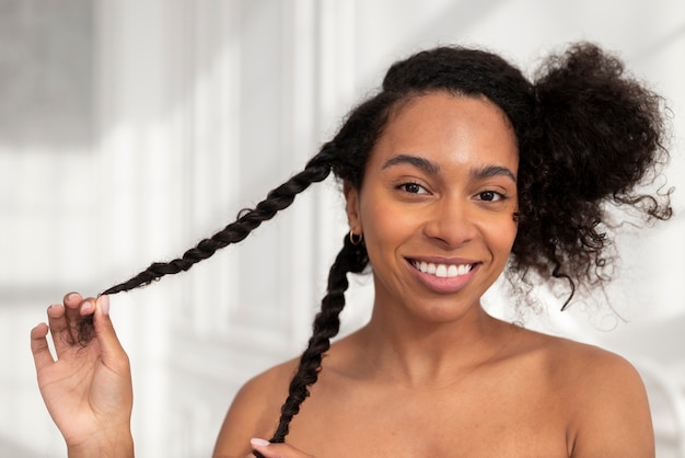 Mujer sonriente peinar el cabello de cerca