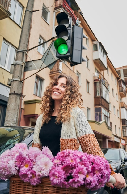 Foto gratuita mujer sonriente, con, pelo rizado, equitación, bicicleta, en, ciudad