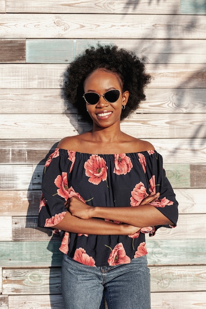 Mujer sonriente de pelo rizado con gafas de sol