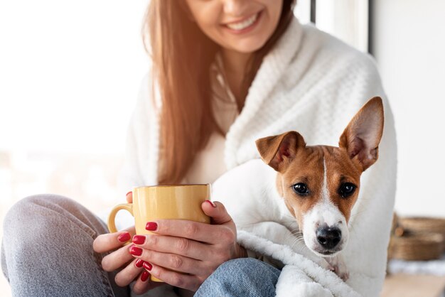 Mujer sonriente con perro en su regazo