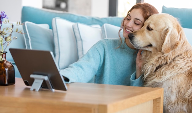 Mujer sonriente y perro con tableta