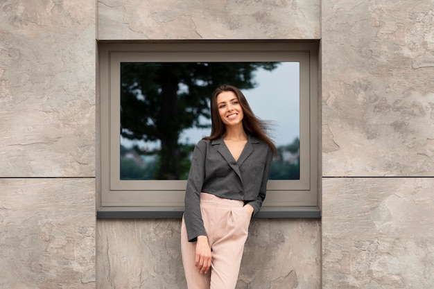 Foto gratuita mujer sonriente de pie en un espacio urbano limpio