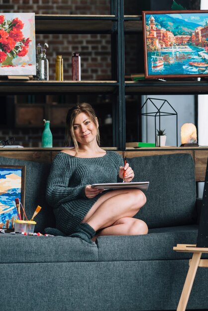 Mujer sonriente pintando en sofá