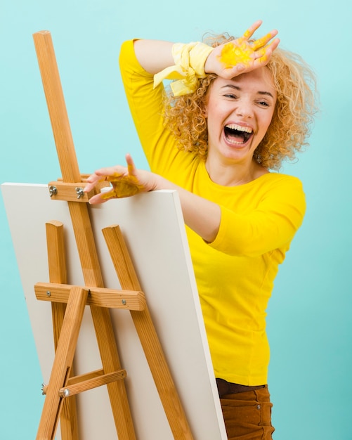 Foto gratuita mujer sonriente con pintura amarilla