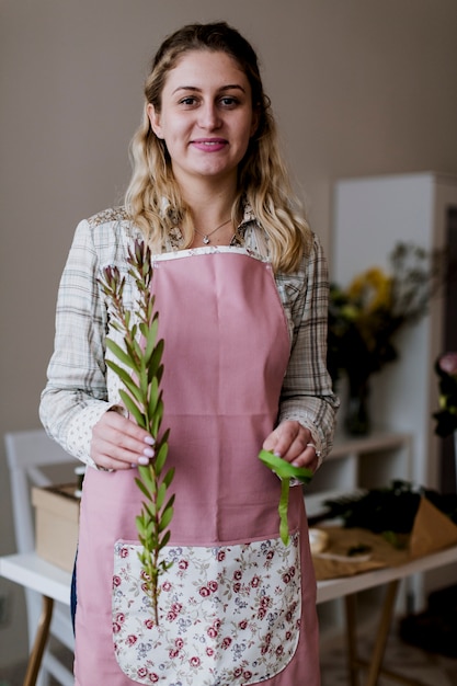 Mujer sonriente con planta y cinta