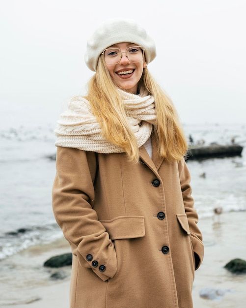 Mujer sonriente en la playa en invierno