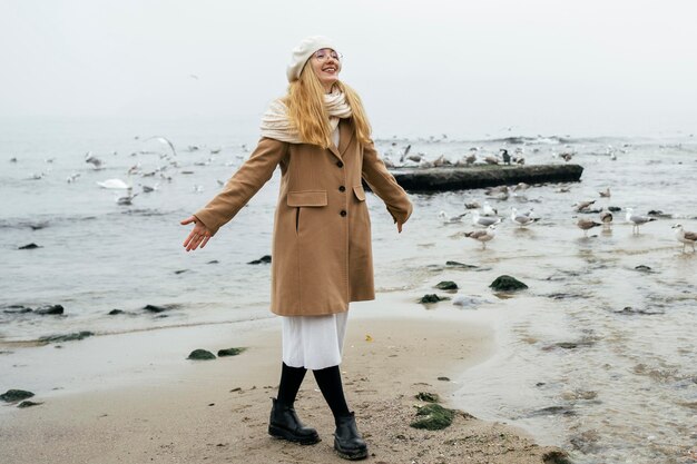 Mujer sonriente en la playa en invierno