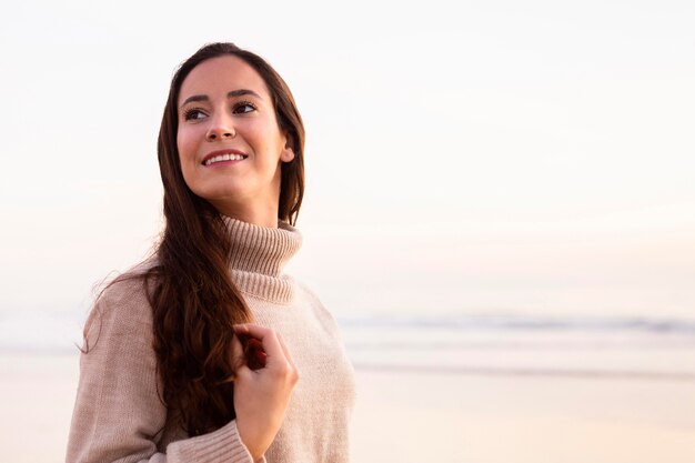 Mujer sonriente en la playa posando con espacio de copia