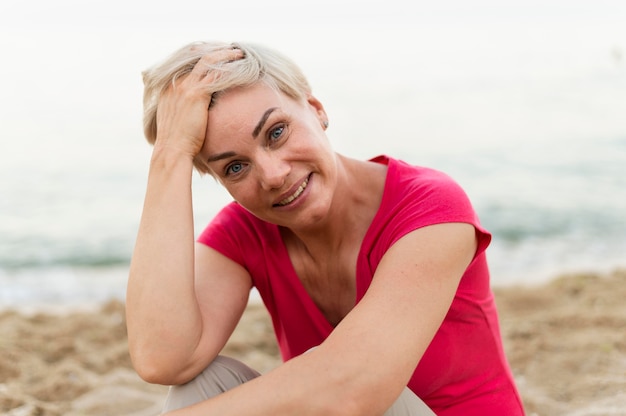 Mujer sonriente en la playa posando