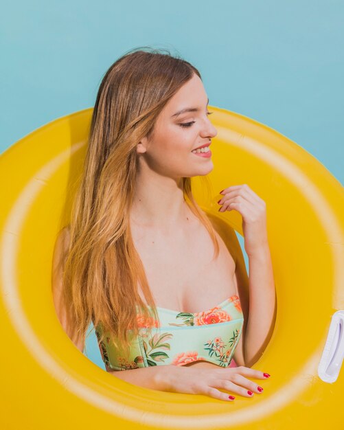 Mujer sonriente en la playa con salvavidas