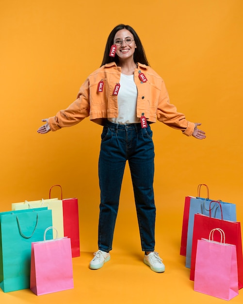 Foto gratuita mujer sonriente posando con bolsas de la compra y etiquetas de venta