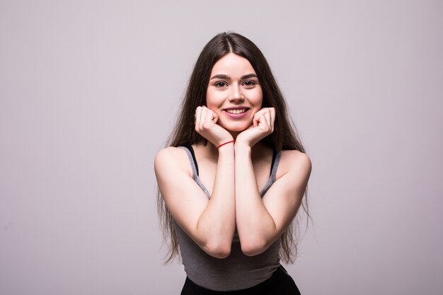 Mujer sonriente posando con el brazo junto a la barbilla