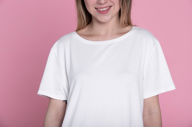 Mujer sonriente posando con camisa blanca