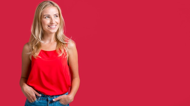 Mujer sonriente posando en camiseta roja con espacio de copia