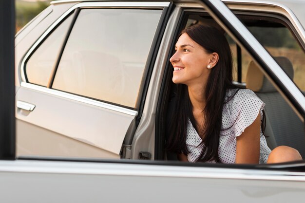 Mujer sonriente posando en coche