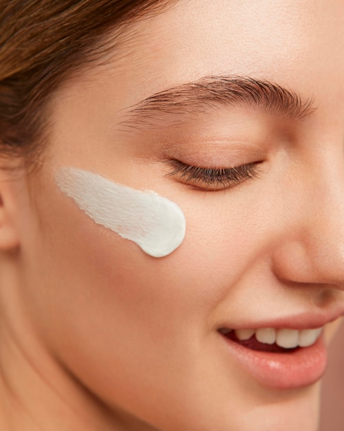 Mujer sonriente posando con crema facial