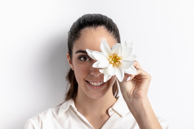 Mujer sonriente posando con flor