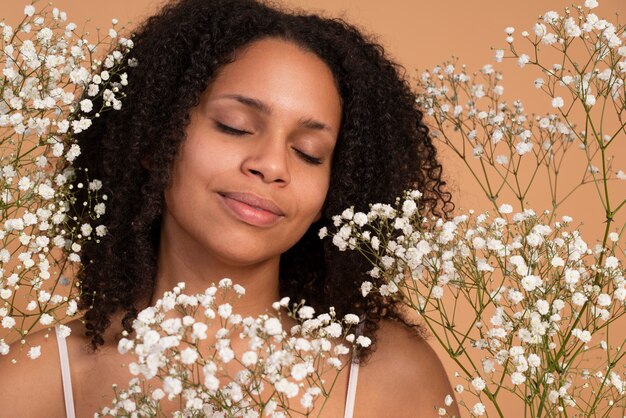 Mujer sonriente posando con flores de cerca