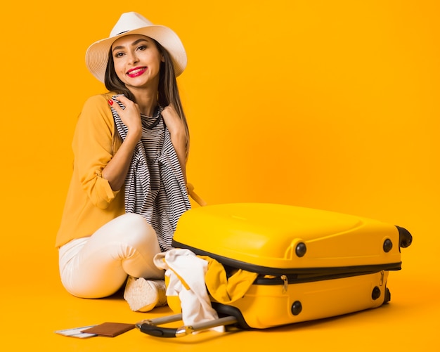 Foto gratuita mujer sonriente posando junto al equipaje listo para vacaciones