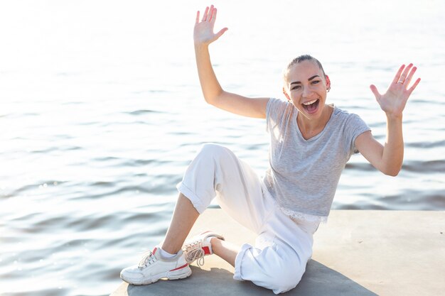 Mujer sonriente posando junto al lago