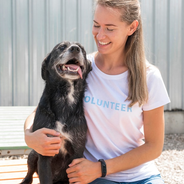 Mujer sonriente posando con lindo perro de rescate