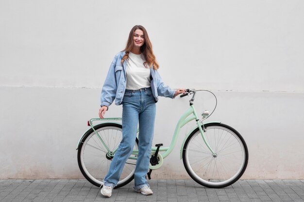 Mujer sonriente posando en la parte delantera de su bicicleta
