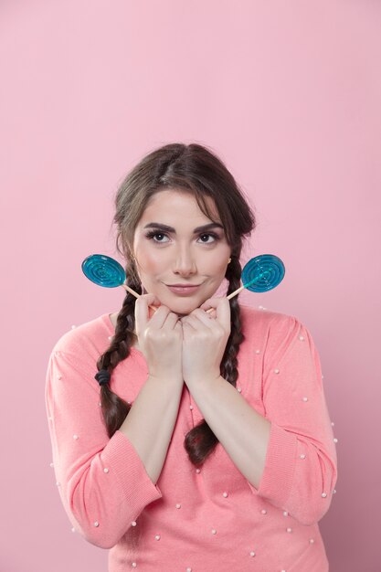 Mujer sonriente posando con piruletas