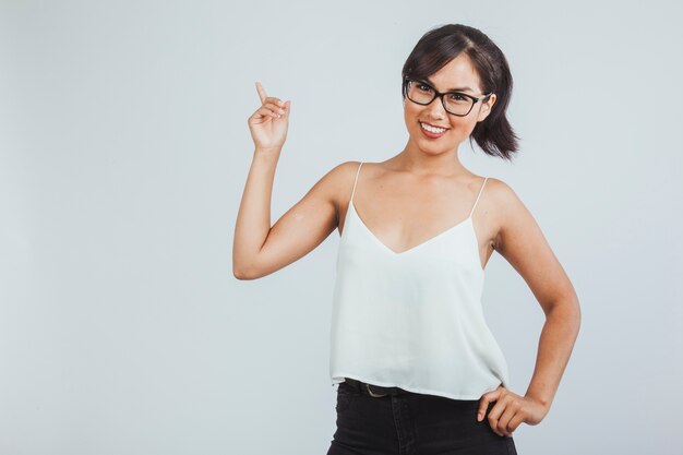 Mujer sonriente posando y señalando